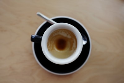 咖啡在杯子碟子勺子旁边
